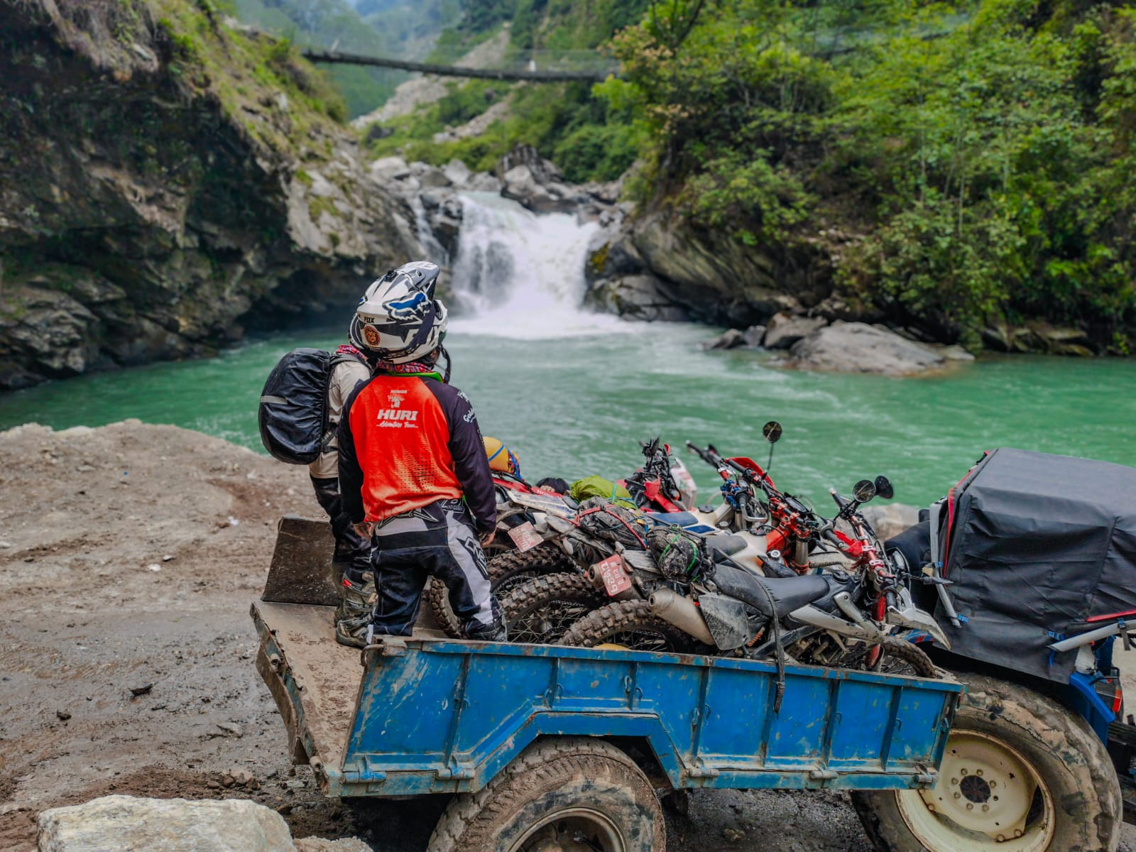 Local villagers helping lift a bike over rocks